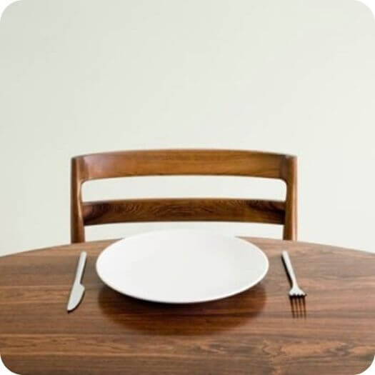 empty white plate with a knife and fork on the table