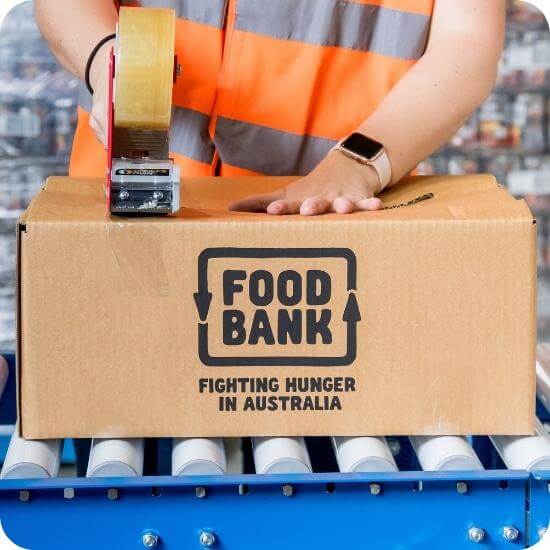 foodbank volunteer taping a hamper box