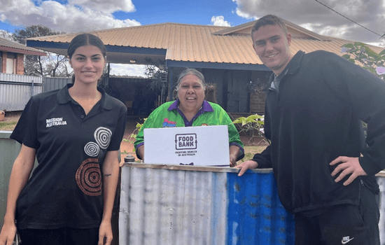 Two Mission Australia staff members distribute an Emergency Hamper