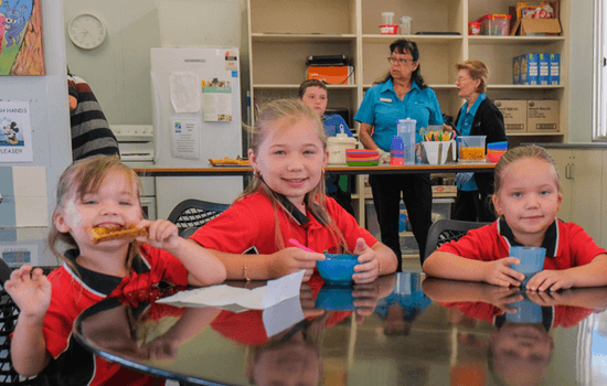 Three cute children eating in the School Breakfast Program