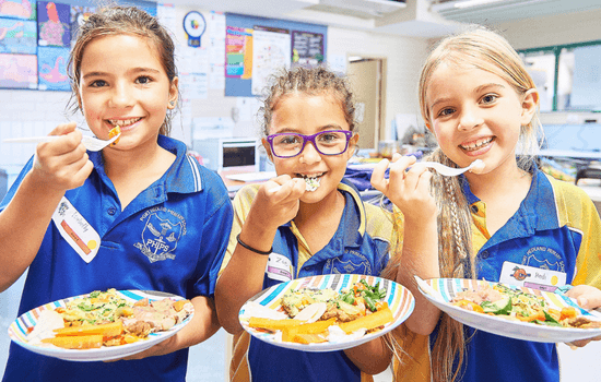 Three children eating from the School Breakfast Program